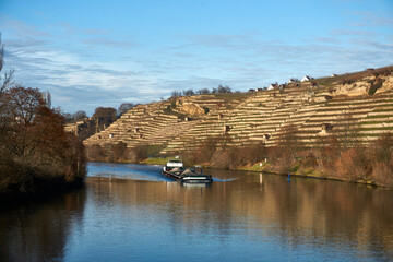 A cargo boat on the neckar for transportation next to a sup standup paddling boat