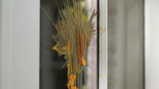Close up of ketchup and mustard from hamburger thrown at window