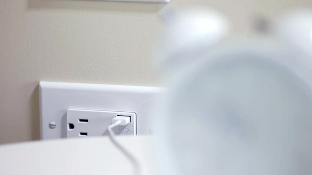 Close up rack focus shot of alarm clock and USB electrical outlet