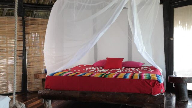 Wind blowing canopy over bed covered with flower petals