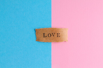 The word LOVE on a pink and blue background. Traditional relationships.