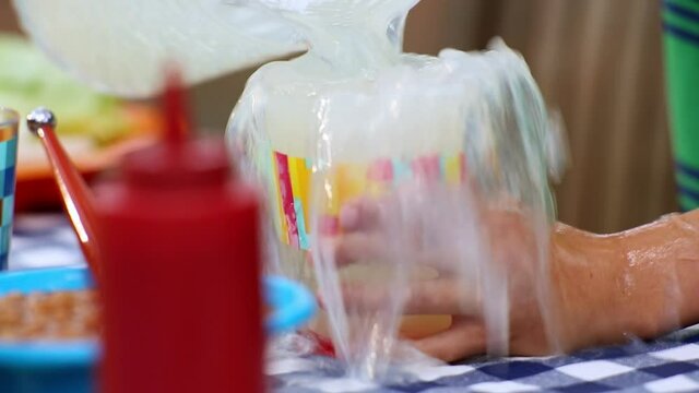 Close up of hand of Caucasian boy spilling lemonade