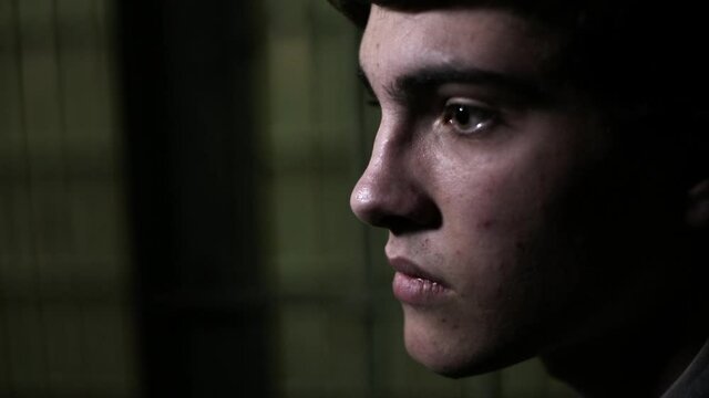 Close up profile shot of Caucasian man talking in dark jail cell