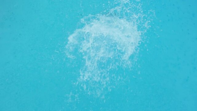 High angle view of Caucasian man flipping into swimming pool