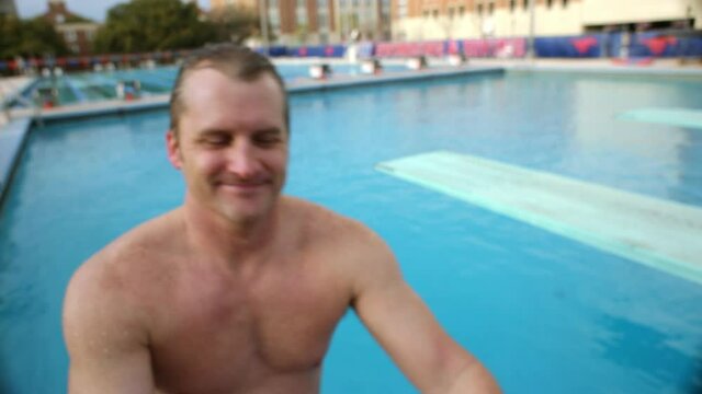 Close up of Caucasian man climbing from swimming pool