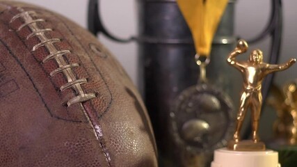 Close up panning shot of variety of football trophies