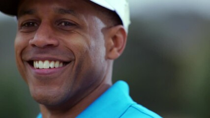 Close up of Black man smiling after swinging golf club