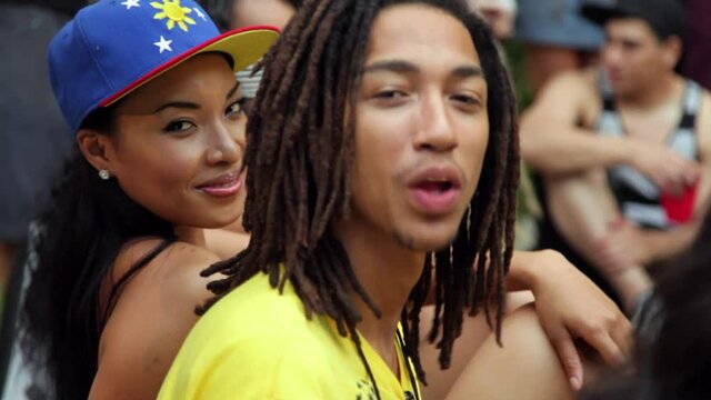 Two people in a group around pool at house party