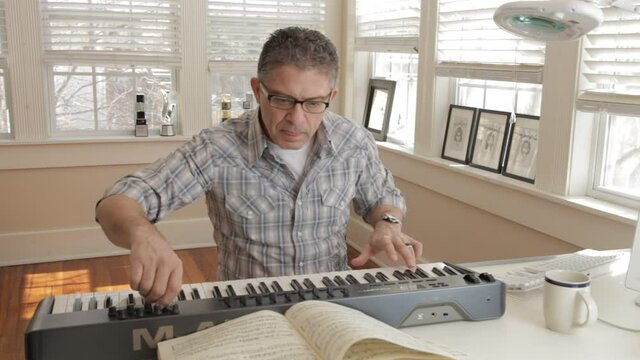 Mixed race man playing keyboard