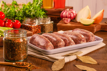 Brazilian pork sausage with chimichurri on white plate with spices and ingredients