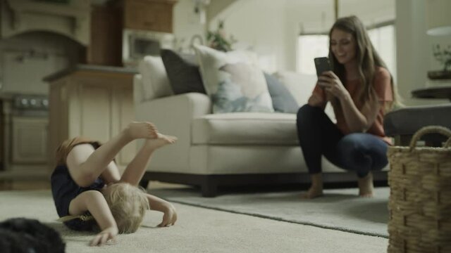 Slow motion of mother recording daughter tumbling with cell phone / Cedar Hills, Utah, United States