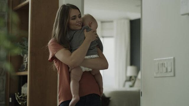Mother carrying sleepy baby boy into bedroom / Cedar Hills, Utah, United States