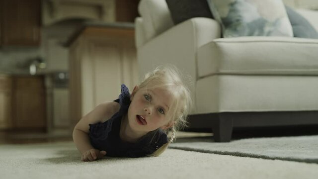Slow motion of girl rolling on floor and looking at camera / Cedar Hills, Utah, United States