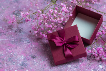 Open gift box on a background of flowers. Valentine's day greeting card