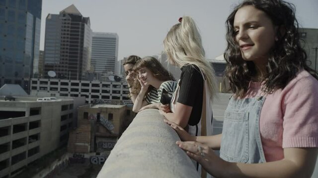 Girls on top level of parking garage looking down at cityscape / Salt Lake City, Utah, United States
