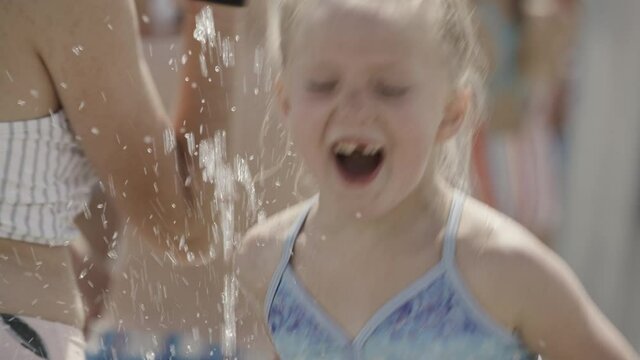 Close up of happy girl jumping in water park splash pad / Cedar Hills, Utah, United States