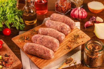 Brazilian pork sausage with chimichurri on wood cutting with spices and ingredients