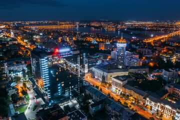 Aerial view night city with illuminated roads, streets and modern buildings in downtown at night dusk. © DedMityay