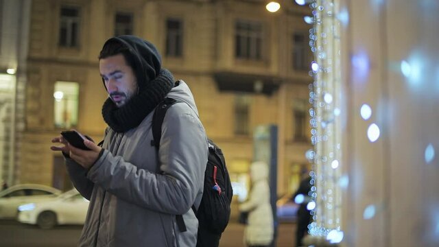 a man looking for a way on the navigator in the phone. Evening in St. Petersburg.
