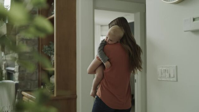 Mother swaying and holding sleepy baby son / Cedar Hills, Utah, United States