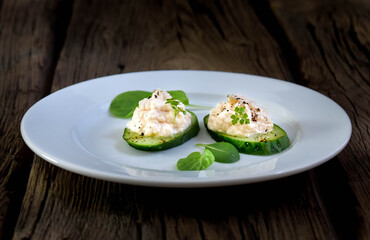 Spicy appetizer of light-salted salmon and cottage cheese on a cucumber