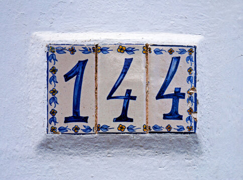 Street sign number 144 on a white wall