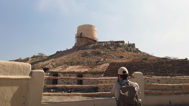 Photographer taking photo of a fort of Hatta heritage village in Hatta town of Dubai emirate in the UAE