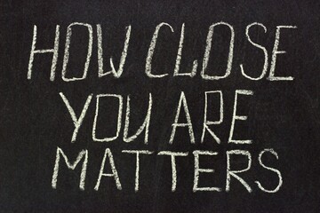 Fototapeta na wymiar Writing on a dark board How clouse you are matters