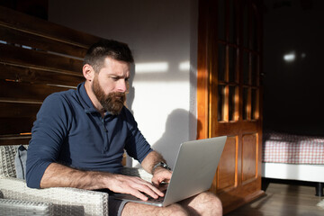 man working on laptop in wooden cottage
