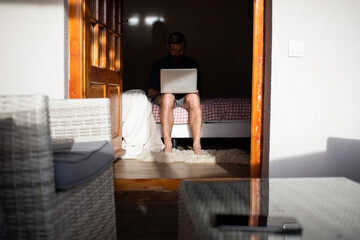 man working on laptop in wooden cottage