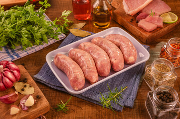 Brazilian pork leg sausage on white plate with spices and ingredients - Linguiça de pernil