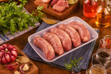 Brazilian pork leg sausage on white plate with spices and ingredients - Linguiça de pernil