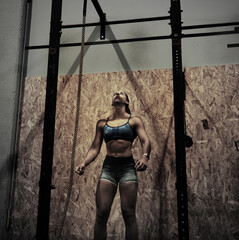 mujer mirando la cuerda para colgarse en el gimnasio