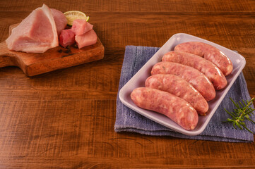 Brazilian pork leg sausage on white plate with pork leg isolated on wood background