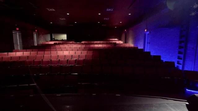 Drama, stage lights, actor theatrics, and lens flares in empty indoor cinema theater during covid-19, 2020