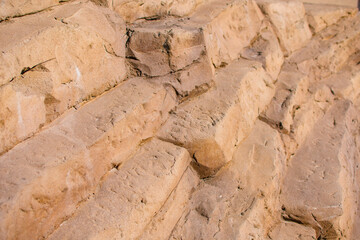 Warm brow rock wall with cracks and rough texture