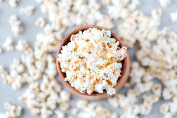 Fototapeta na wymiar Flat lay fresh popcorn in a wooden bowl on a grey background