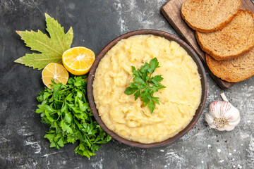 top view mashed potatoes bread slices on cutting board parsley lemon slices on dark background