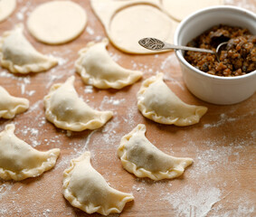 A close-up view of traditional dumplings with vegetarian filling during preparation on a wooden board
