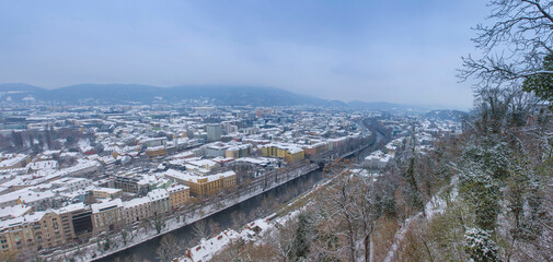 Cityscape of Graz with Mur river and historic buildings rooftops in winter with snow, in Graz, Styria region, Austria