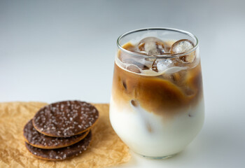 close up a glass of iced coffee with chocolate biscuit on white background. Afternoon coffee drink in the summer.