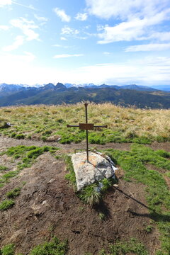 A cross with the inscript "Berg heil" stands directly aside the mountain trail above the Reiteralm