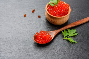 fresh grainy red chum salmon caviar in a wooden spoon, delicious and healthy food