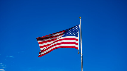 Obraz premium USA Flag waving in the blue sky