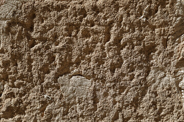 Sunlight on a stone wall with rough surface, brown and bright background for template, no person