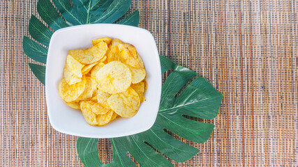 Crispy Peruvian sweet potato chips in white square bowl on wood