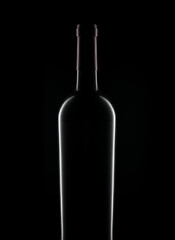 Closeup silhouette of a bottle of red wine over a black background.