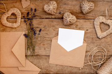 festive flat lay for Valentine's Day from do it yourself decoration. Jute hearts, lavender flowers, craft paper envelope. Zero waste Valentine's Day concept and mock up.