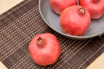 Pomegranates on a bamboo mat