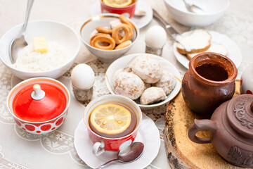 Traditional Russian or Ukrainian breakfast: eggs, rice porridge, honey, bagels (sushki) and tea with lemon. Traditional Russian or Belarusian cuisine. Russian traditional gingerbread cookies.